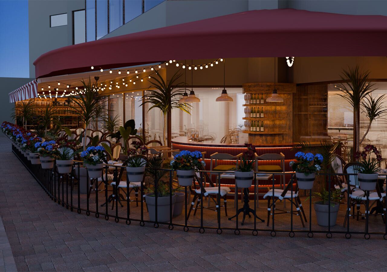 An outdoor cafe area with tables and chairs, potted plants, and string lights.