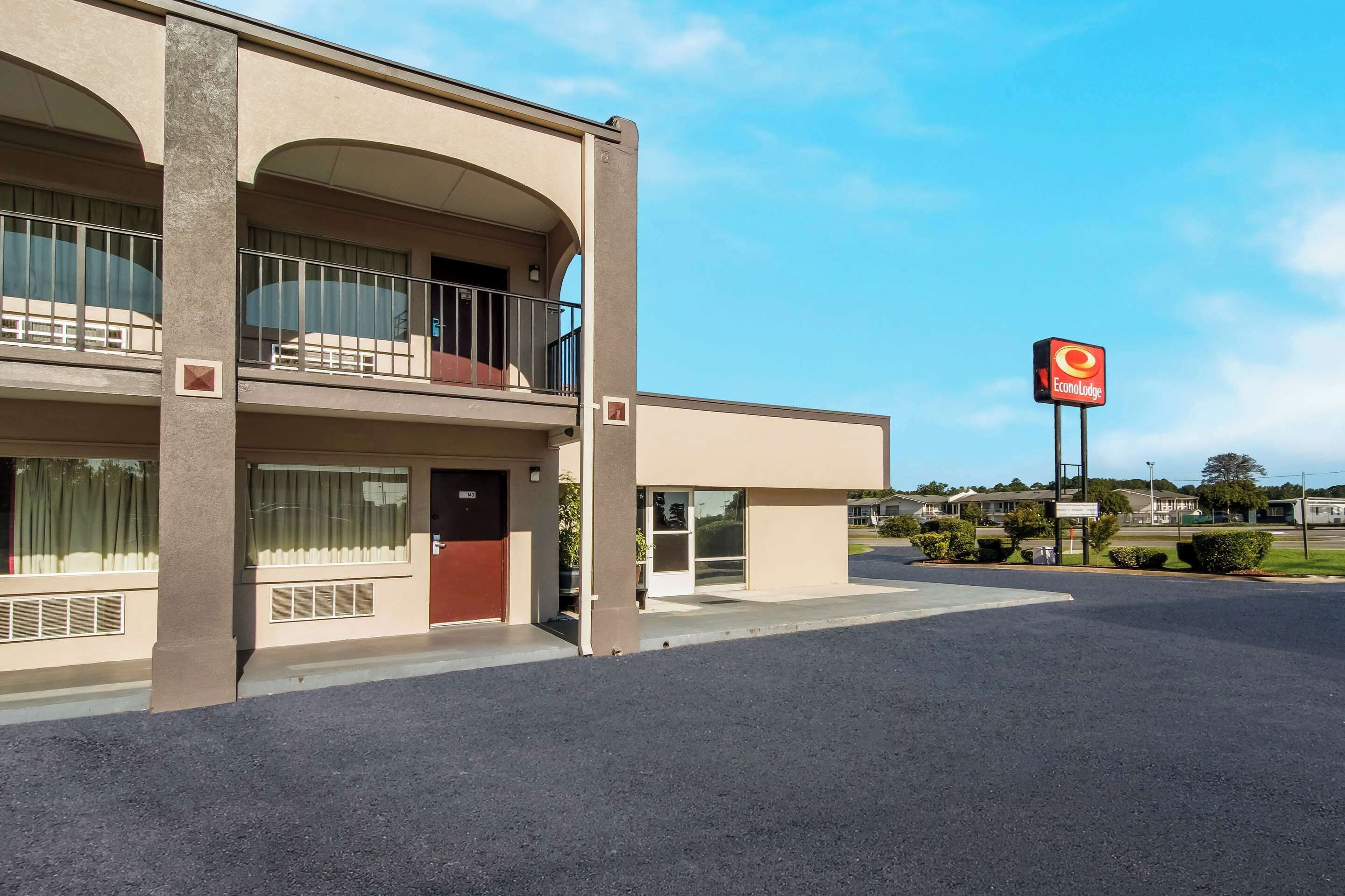Un motel con estructura de dos pisos, un balcón en el piso superior y una señal visible de la marca 'Econolodge'.