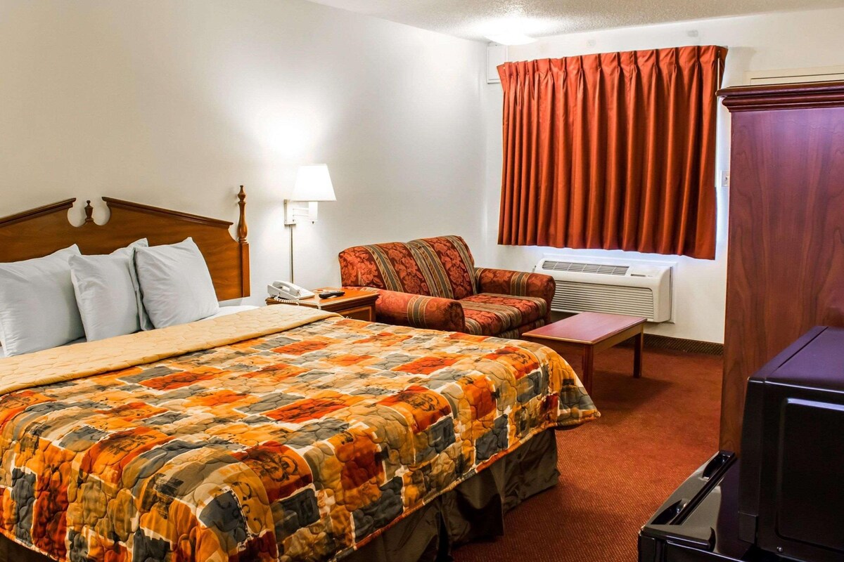 Een hotelkamer met een groot bed, een bank, een bureau en een televisie.