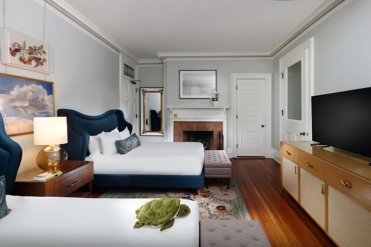 Une chambre d’hôtel équipée d’un lit, d’une télévision, d’une cheminée et d’un bureau avec des tiroirs.