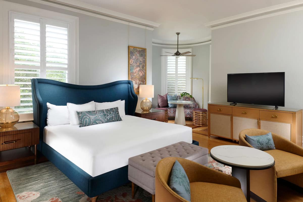 Une chambre d’hôtel avec un grand lit, une télévision, un bureau et une chaise.