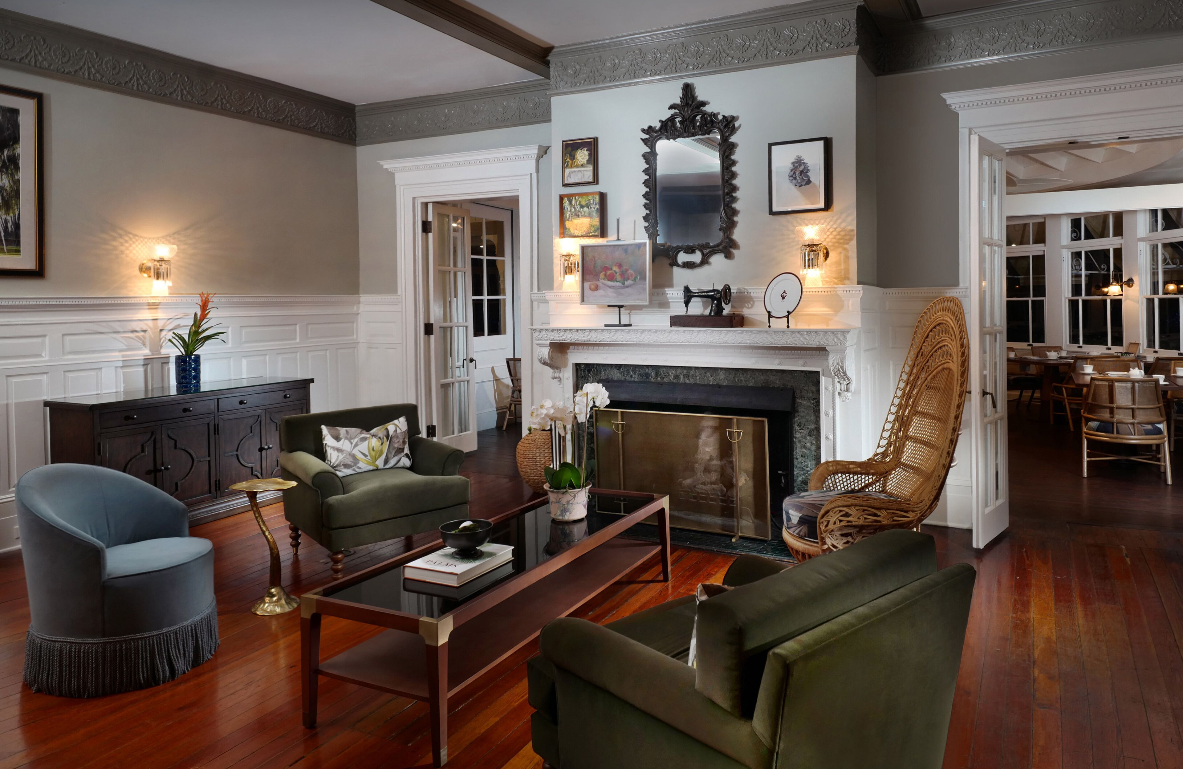 A spacious living room with a fireplace, comfortable seating, and a dining area visible through an open doorway.
