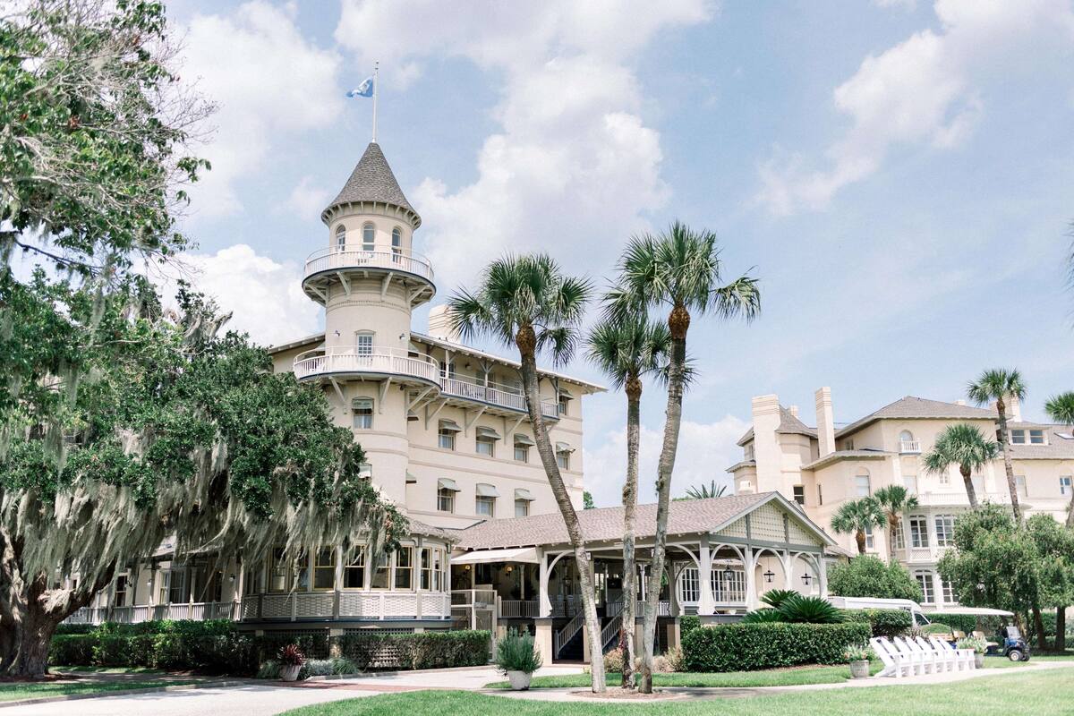 Un grand hôtel à plusieurs étages, doté d’une tour imposante et d’un patio couvert.