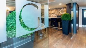 A modern interior with a glass partition, a stone wall, and a bar area.