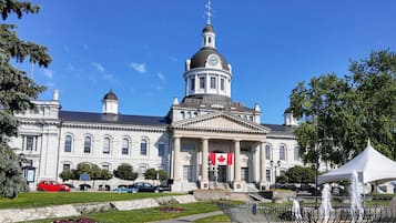 A large, historic building with a prominent dome and a flag.