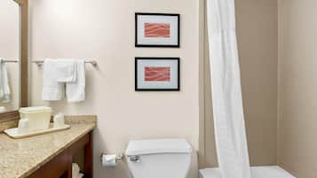 A bathroom with a toilet, sink, and framed artwork on the wall.