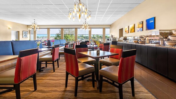 A restaurant with booths and tables, a chandelier, and a view of the outdoors. - Comfort Inn Somerset (Somerset)