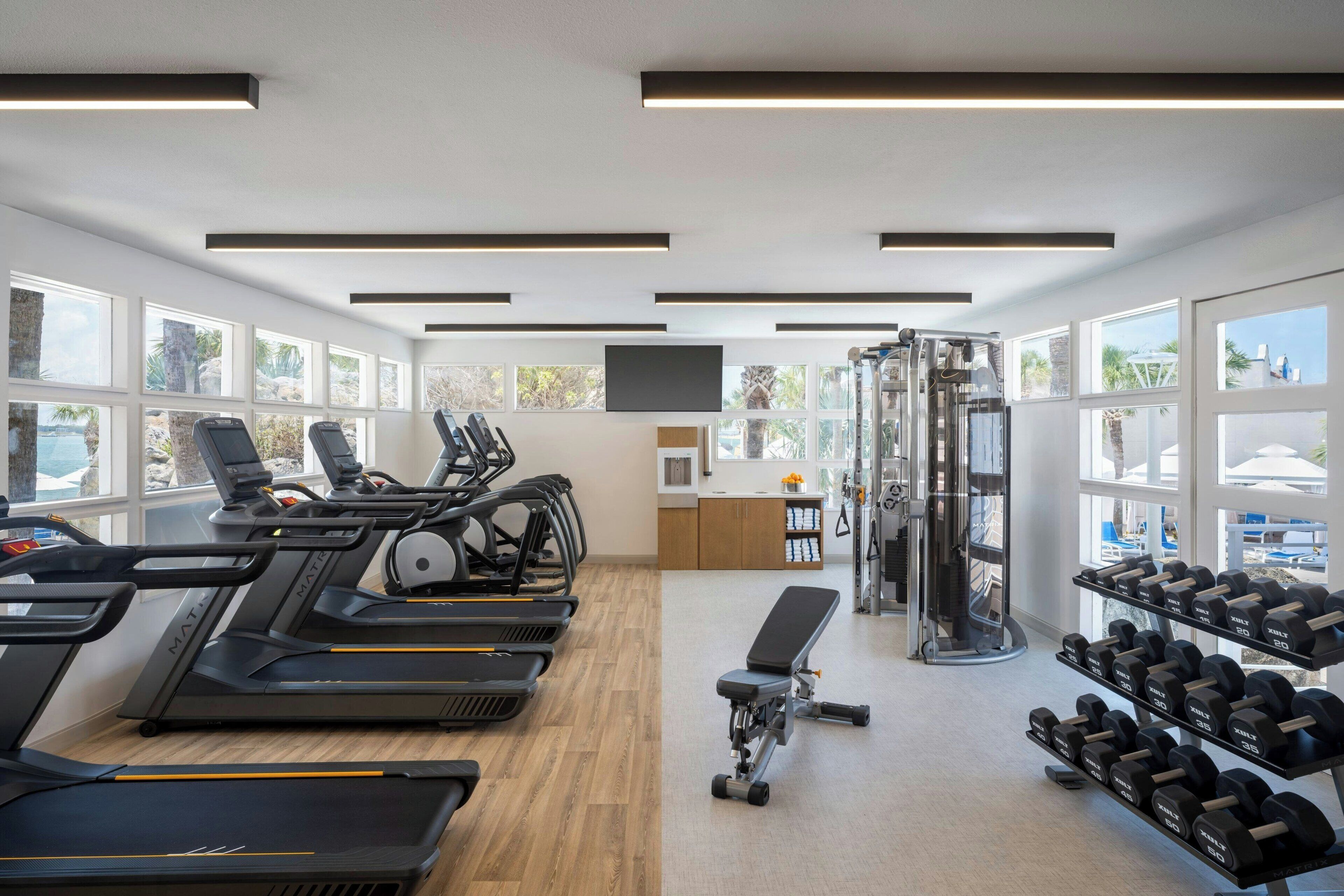 Ett gym med löpband, hantlar och styrketräningsmaskiner.