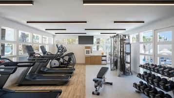 A gym with treadmills, dumbbells, and weight machines.