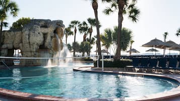 Una piscina al aire libre, camas de piscina gratis, sombrillas