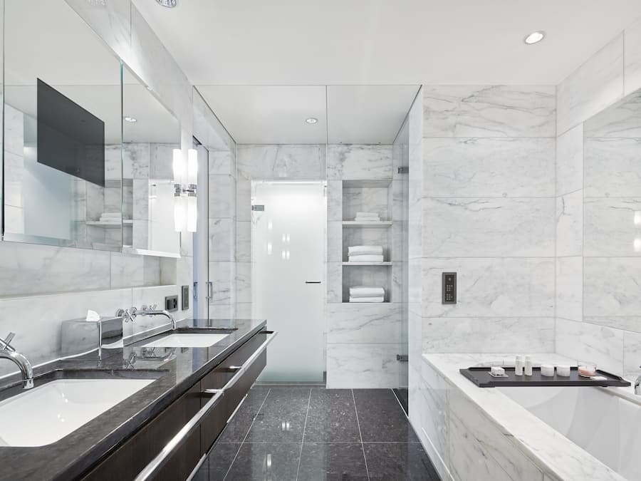 Ein modernes Badezimmer mit zwei Waschbecken, einem großen Spiegel und einer Badewanne.