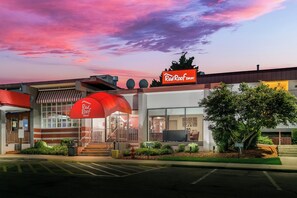 A Red Roof Inn with a modern design, a covered entrance, and a parking lot. - Red Roof Inn Baltimore (Baltimore)