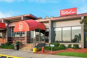 A Red Roof Inn with a red awning, a fire hydrant, and a parking sign indicating 15-minute parking. - Red Roof Inn Baltimore (Baltimore)