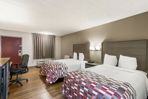A hotel room with two beds, a desk, a chair, a desk lamp, a telephone, and a window with curtains. - Red Roof Inn Baltimore (Baltimore)