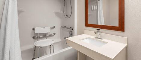 A modern bathroom with a bathtub, shower, and sink.