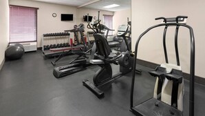 Ein Fitnessstudio mit Laufbändern, Crosstrainern und Kurzhanteln.