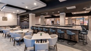 A modern restaurant with a bar area, multiple seating options including bar stools and tables, and a contemporary interior design. - DoubleTree by Hilton Denver Cherry Creek (Denver)