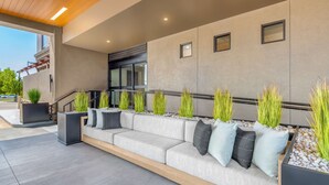 A modern outdoor seating area with a sofa, planters, and a staircase. - DoubleTree by Hilton Denver Cherry Creek (Denver)