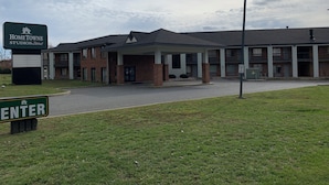 A building with a covered entrance, a sign for Hometown Studios, and a speed limit sign.