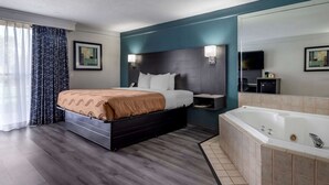 A modern hotel room with a large bed, a separate bathroom with a bathtub, and a flat-screen TV on the wall. - Quality Inn Rock Hill Northeast I-77 (Rock Hill)