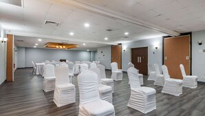 A conference room with rows of white-covered chairs, wooden flooring, and a ceiling with recessed lighting. - Quality Inn Rock Hill Northeast I-77 (Rock Hill)