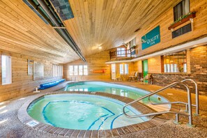 An indoor swimming pool with a wooden interior, a balcony with a view, and a sign for Quality Inn. - Quality Inn Saint Ignace I-75 (St Ignace)