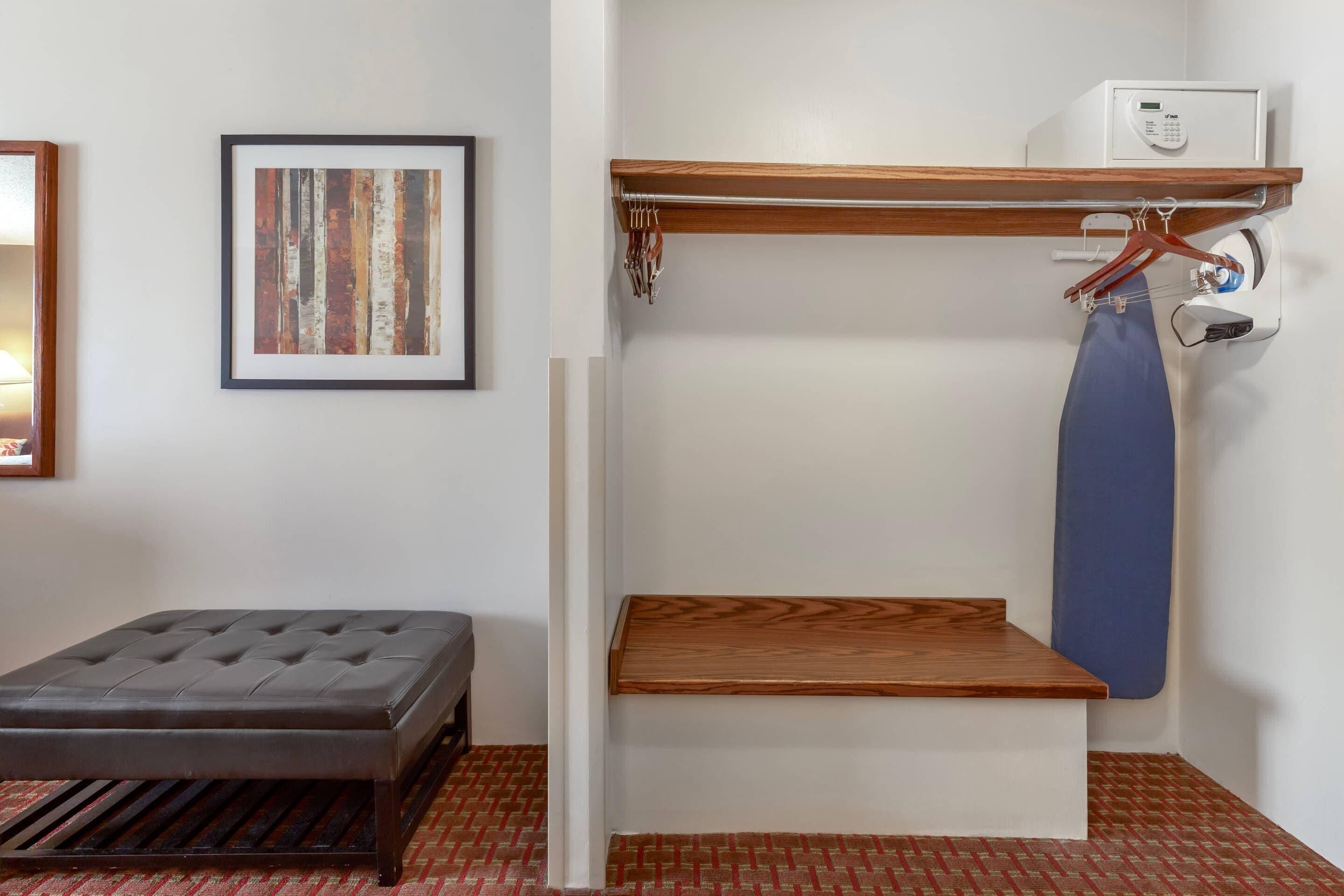 Una habitación con literas, una pequeña mesa de madera, un cuadro abstracto enmarcado y un calentador fijado a la pared.