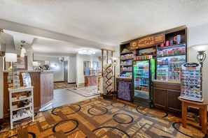A lobby area with a reception desk, a vending machine, and a display of eyewear. - Quality Inn Saint Ignace I-75 (St Ignace)