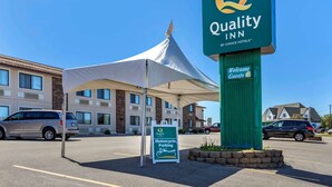 A Quality Inn sign, a tent, and a motorcycle parking sign. - Quality Inn Saint Ignace I-75 (St Ignace)
