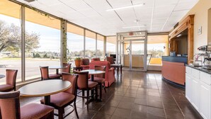 A restaurant with a view of the parking lot, featuring tables and chairs, a counter, and a door marked "EXIT". - Econo Lodge Gaffney (Gaffney)