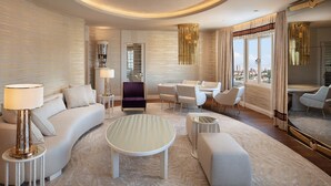 A modern living room with a curved sofa, a round coffee table, and a dining area with white chairs. - Sheraton Ankara Hotel & Convention Center (Ankara)