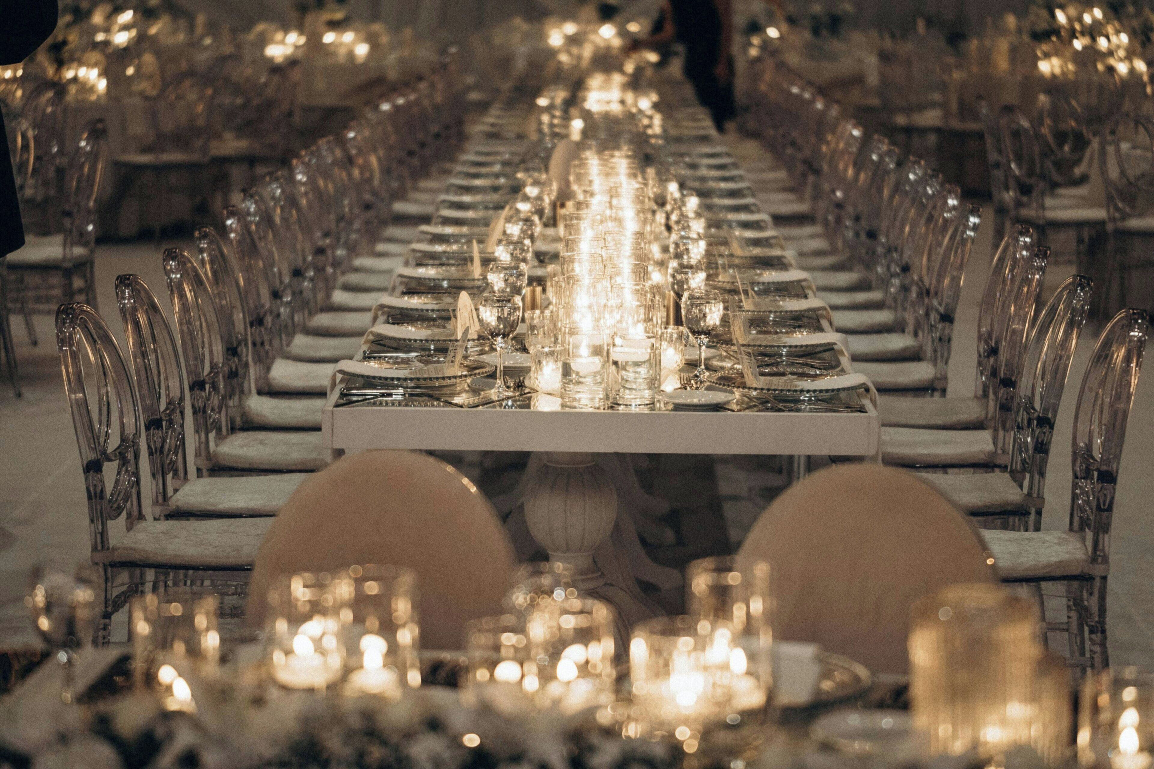 Una larga mesa de comedor con sillas y velas, evocando un ambiente formal para cenar.
