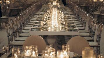 Una larga mesa de comedor con sillas y velas, evocando un ambiente formal para cenar.