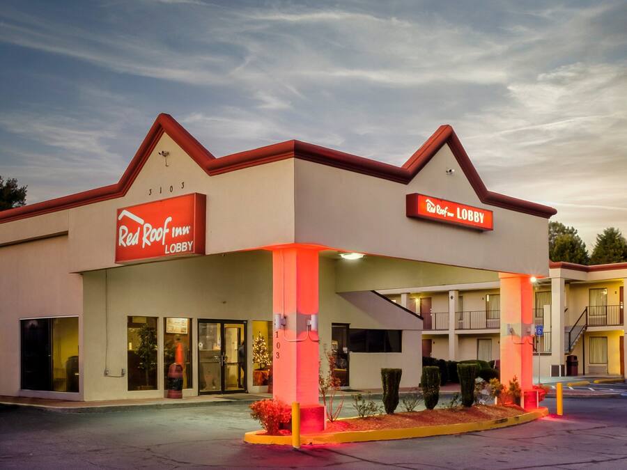 A Red Roof Inn with a lobby entrance, a visible staircase, and a parking lot.