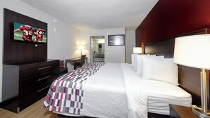 A hotel room with a bed, a desk, a television, and a microwave. - Red Roof Inn Atlanta - Suwanee/ Mall of Georgia (Suwanee)