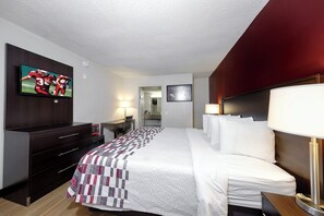 A hotel room with a bed, a desk, a television, and a microwave. - Red Roof Inn Atlanta - Suwanee/ Mall of Georgia (Suwanee)