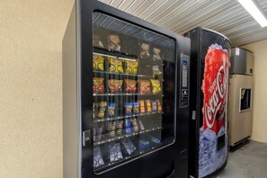 A vending machine with snacks and a Coca-Cola refrigerator. - Red Roof Inn Atlanta - Suwanee/ Mall of Georgia (Suwanee)