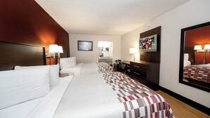 A hotel room with a bed, a desk, a chair, a TV, and a mirror. - Red Roof Inn Atlanta - Suwanee/ Mall of Georgia (Suwanee)