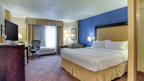 A hotel room with a large bed, a desk with a computer, a chair, a TV, and a window with curtains. - Holiday Inn Indianapolis Carmel by IHG (Indianapolis)