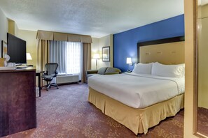 A hotel room with a large bed, a desk with a computer, a chair, a TV, and a window with curtains. - Holiday Inn Indianapolis Carmel by IHG (Indianapolis)