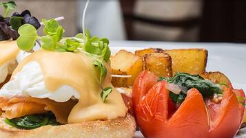 A breakfast plate with eggs benedict, smoked salmon, and roasted potatoes.