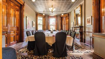 A formal dining room with a long table, chairs, and a chandelier.