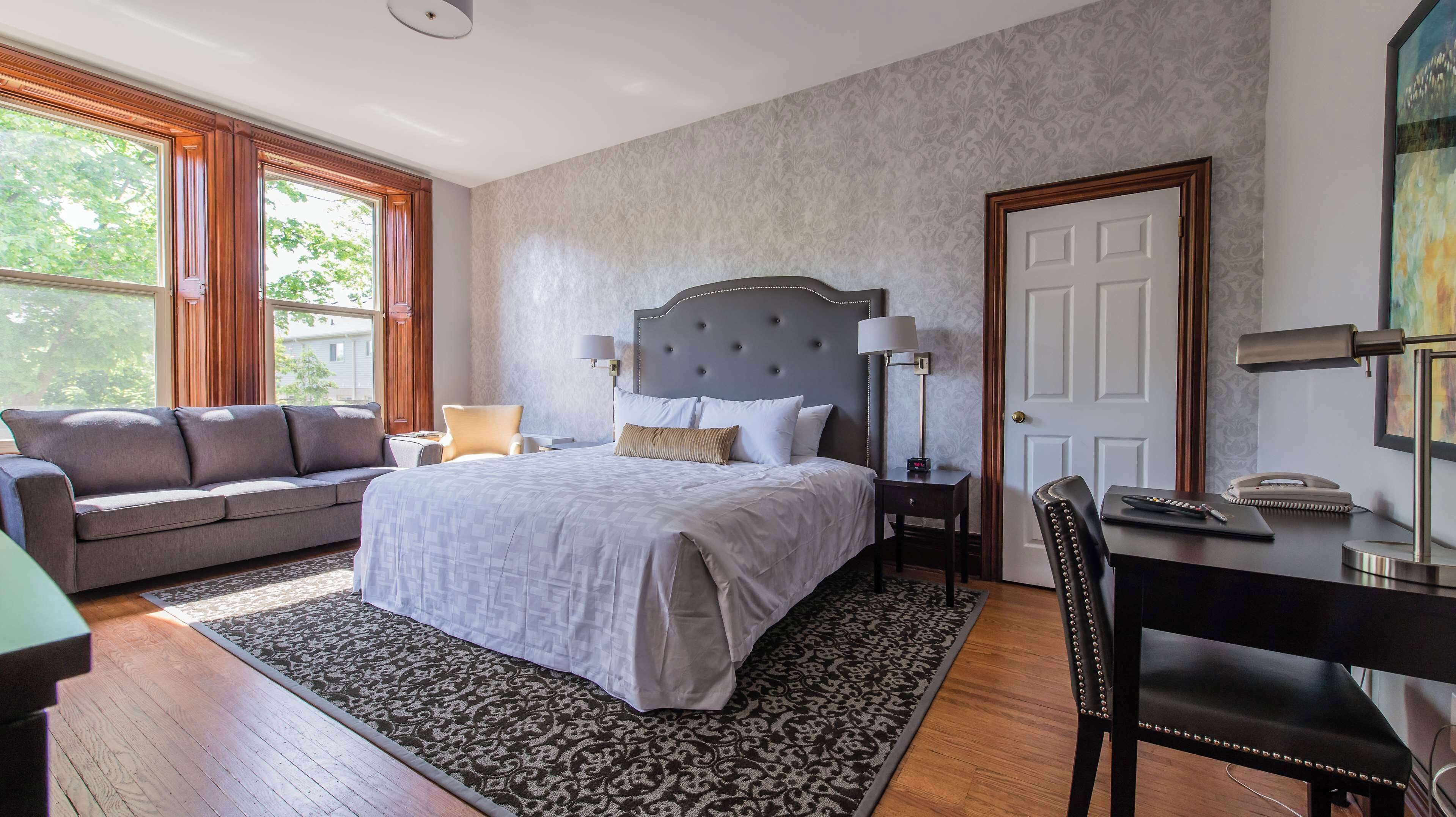 Una habitación de hotel con una cama grande, un sofá, un escritorio y una silla.