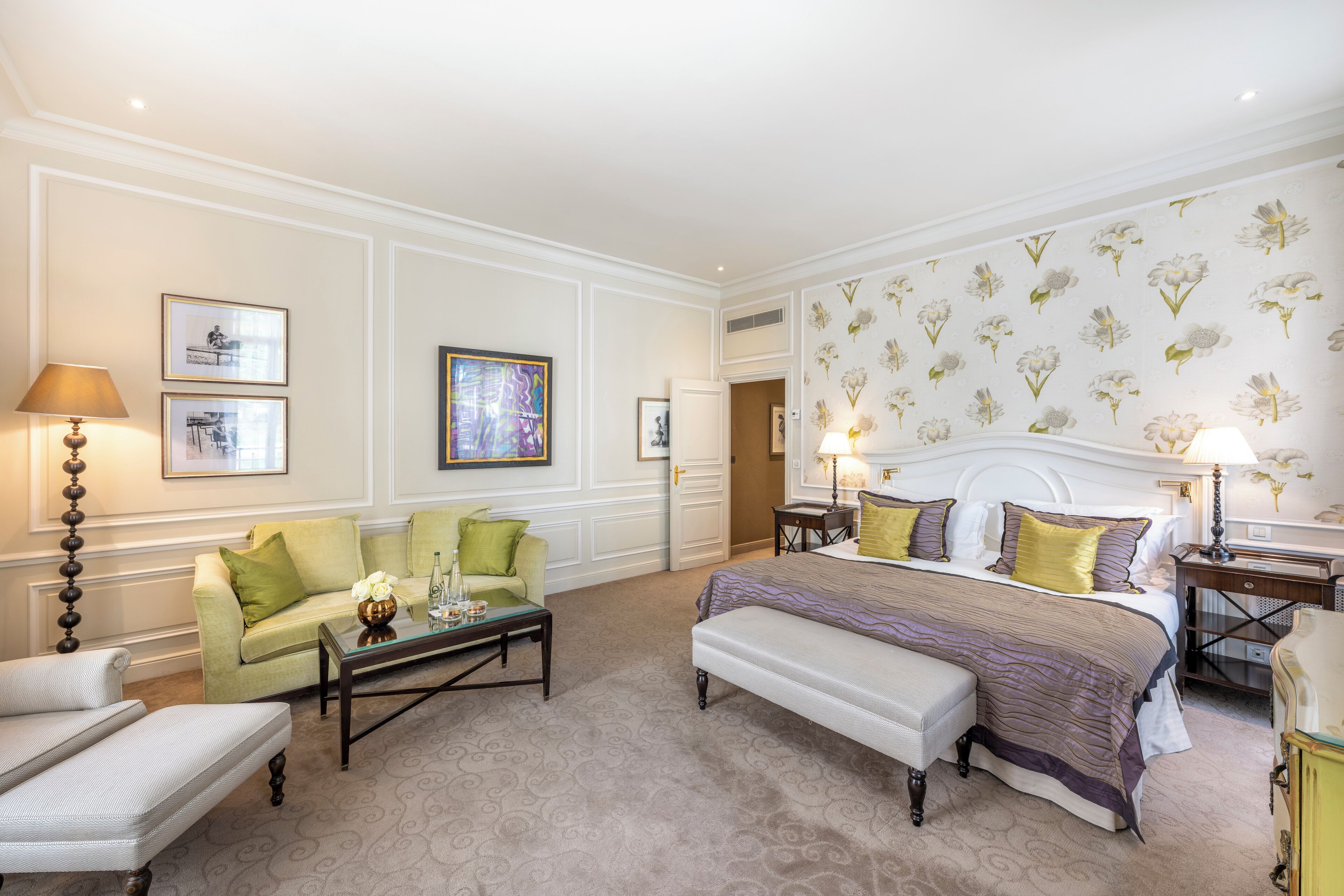 Ein Hotelzimmer mit einem Bett, zwei Sesseln, einem Couchtisch und einem kleinen Tisch mit einer Lampe.