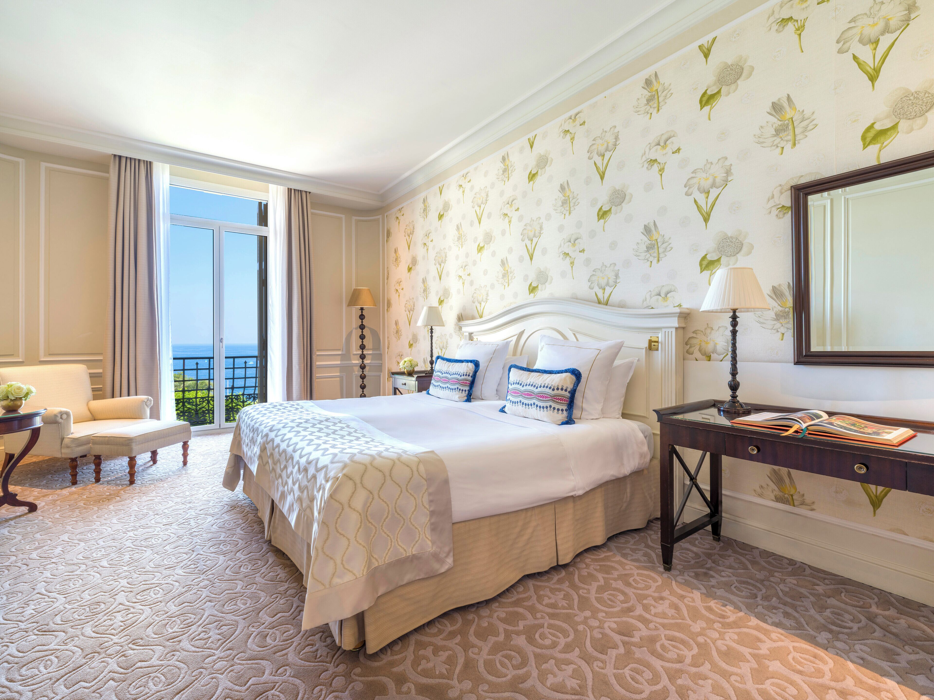 Une chambre d’hôtel avec un grand lit, une chaise, un bureau et une vue sur l’extérieur.