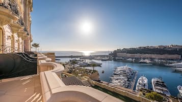 A marina with boats, a clear sky, and a building with balconies.