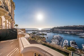 A marina with boats, a clear sky, and a building with balconies.