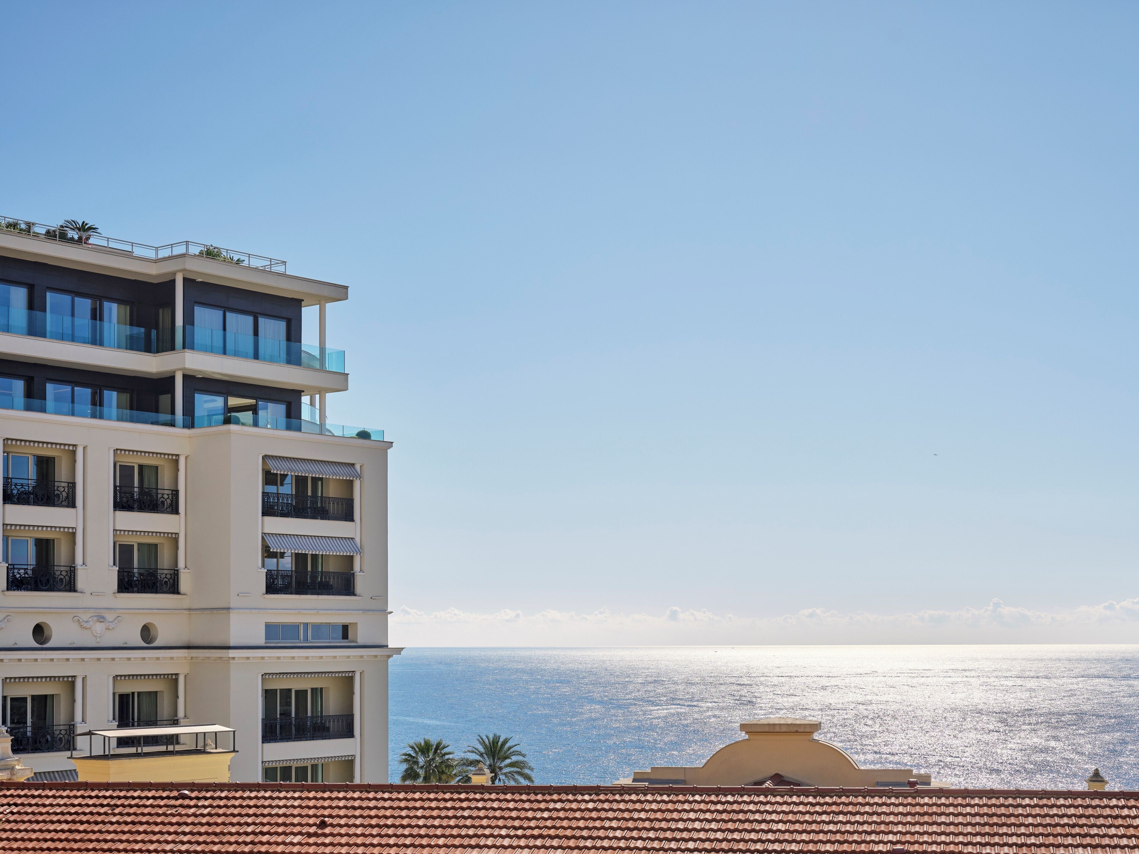 A multi-story hotel with balconies overlooking a coastal view.