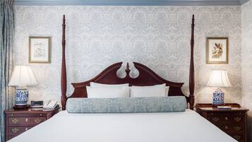 Ein Bett mit Baldachin, ein hölzernes Kopfteil, zwei Nachttische mit Lampen und eine Wand mit Muster