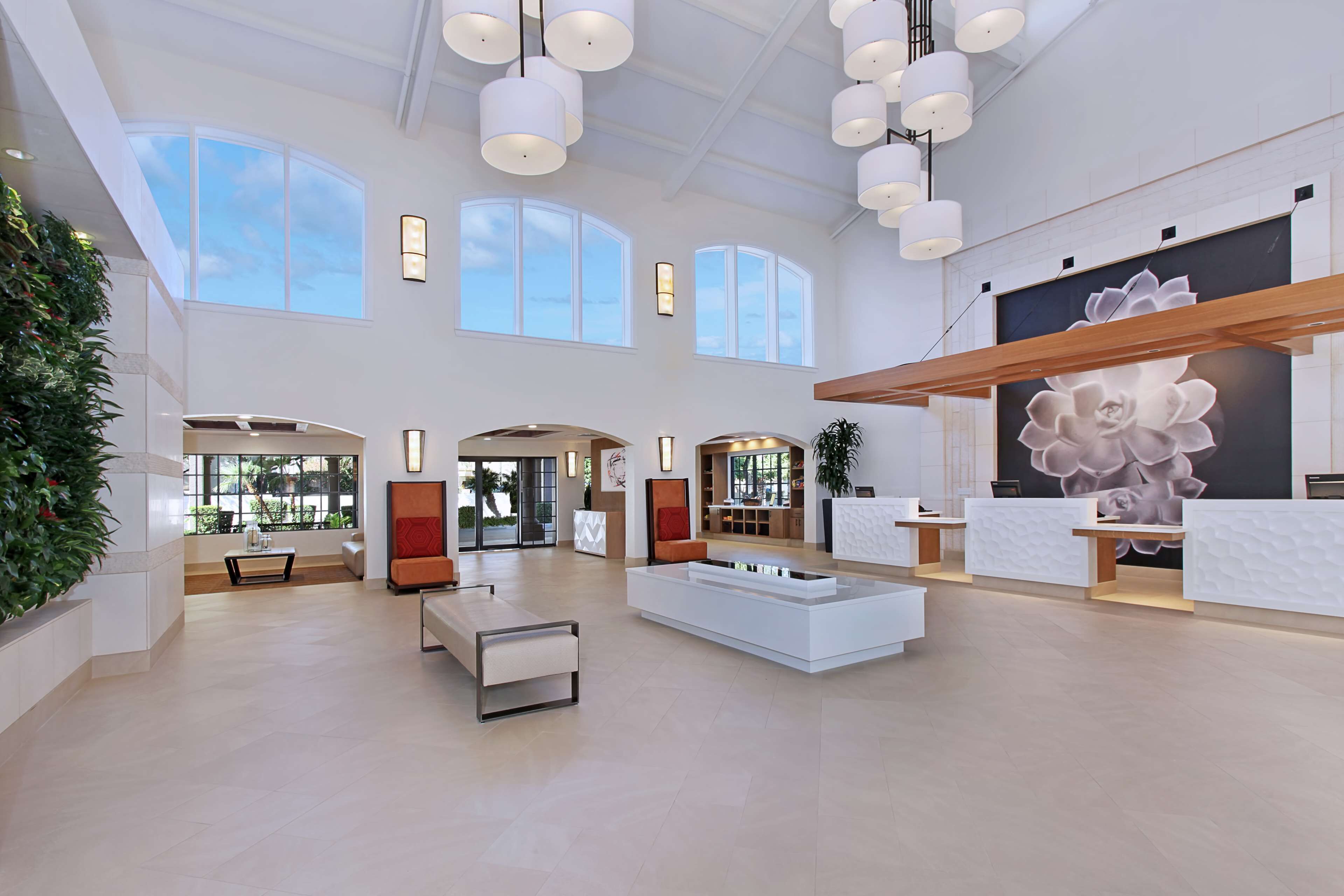A spacious lobby with high ceilings, large windows, and modern furniture.